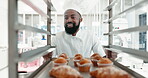 Muffins, pastry chef and a man in a restaurant kitchen for baking job. Happy professional black person working with food at work with hotel or bakery trolley for production, breakfast or service