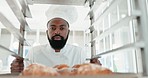 Trolley, pastry chef and man in restaurant kitchen for baking job. Portrait of black person or baker with food in catering or bakery industry for production, breakfast croissant or commercial service