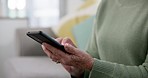 Phone, hands and senior woman typing a text message on social media or mobile app on a sofa. Technology, networking and closeup of elderly female person in retirement on a sofa on a cellphone at home