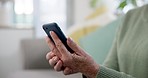 Cellphone, hands and senior woman on a sofa scroll on social media, mobile app or the internet. Technology, closeup and elderly female person in retirement browsing on website with a phone at home.