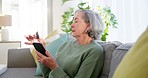 Phone, credit card and senior woman on sofa in the living room for online or ecommerce shopping. Technology, relax
and elderly female person in retirement paying debt, bills or mortgage on cellphone.