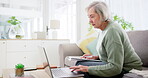 Laptop, writing and investment for finance with an old woman in the living room for retirement planning. Computer, accounting and documents for pension with a senior adult on a sofa in her home