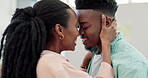 Love, man and woman kiss in home for support, smile and intimate bonding in relationship together. Face of black couple, romantic partner and kissing for trust, loyalty and happy anniversary date 