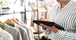 Woman, tablet and hands for clothing rack inspection, inventory or fashion in small business at boutique store. Closeup of creative female person with technology for logistics, design or startup shop