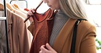 Woman, hands and clothes on rack in shopping, fashion or style at boutique store or indoor mall. Closeup of female person or customer checking clothing, fabric or material at retail shop or tailor
