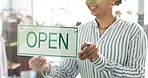 Happy woman, hands and open sign on window in small business, fashion or clothing at boutique store. Closeup of creative female person or owner with label ready for service in retail shop or startup