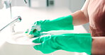 Hands, sponge and washing dishes in the kitchen for hygiene, sustainability or domestic housework. Cleaning, water and remove bacteria with a person in gloves at a home for housekeeping as a cleaner