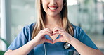 Hands, heart and health with a nurse woman in a hospital closeup for love, medical support or trust. Smile, healthcare and emoji with a happy medicine professional in a clinic for expert cardiology