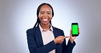 Happy black woman, phone and pointing to green screen mockup against a grey studio background. Portrait of business African female person smile with mobile smartphone app or display in advertising