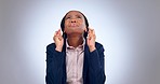 Hope, business woman and fingers crossed in studio for luck, thinking and anxiety while waiting for announcement on grey background. Nervous african worker, hand emoji and praying for wish of winning