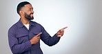 Pointing, smile and man in a studio with mockup for marketing, promotion or advertising. Happy, excited and young male person from Mexico with show hand gesture for mock up space by white background.