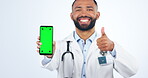 Doctor, phone green screen and thumbs up for healthcare presentation, advertising or social media like in studio. Face, yes and medical man on mobile telehealth, tracking markers and white background