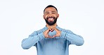 Heart, hands and face of man in studio for thank you, happy and gesture of kindness, hope or care on white background. Smile, portrait and male model with hand emoji for support, vote or love promo