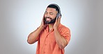 Music, headphones and dance in studio happy with streaming, podcast or track on grey background. Radio, earphones and guy model dancing to feel good sound, playlist or audio, album or song with smile