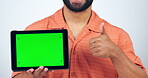 Tablet, green screen and man thumbs up, ok hands and success of social media subscription or marketing in studio. Person with digital technology and like emoji, tracking marker and a white background