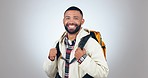 Hiking, backpack and face of man in studio excited for to explore on adventure, journey and holiday. Travel, happy and portrait of person with bag for trekking, hike and camping on gray background