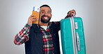 Man, celebration and passport or suitcase for travel opportunity, vacation or excited for holiday in studio. Face of Funny person with flight ticket, luggage and happy dance on a white background