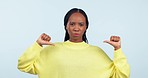 Stop, thumbs down and no of woman face with dislike emoji hand gesture for protest and ban. Portrait, serious and African female person in studio with blue background with opinion and reject vote