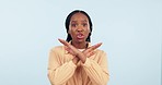 Stop, hand and no vote of woman face with angry protest, warning and ban emoji sign. Portrait, serious and African female person in a studio with blue background with opinion of reject and refuse