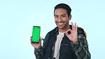 Happy asian man, phone and palm with green screen or mockup in advertising against a studio background. Male person or tourist show OK, like or yes sign for perfect mobile smartphone app or display