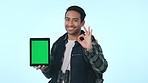 Happy asian man, tablet and pointing to green screen or mockup in advertising against a studio background. Portrait of male person smile with like emoji, OK or yes sign for technology, app or display