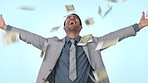 Business man, money shower and studio with celebration, success and financial freedom by blue background. Entrepreneur, trader and cash in air for winner, goals and prize in lotto, gambling or stocks