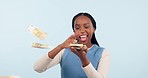 Happy black woman, money and financial freedom for winning, lottery or savings against a studio background. Excited African female person blowing cash, paper or bill in happiness or finance on mockup