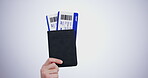 Hand, passport and flight tickets for travel closeup in studio on a gray background at the airport for a trip. Boarding pass, documents for immigration and a passenger getting ready for departure