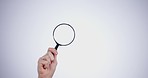 Magnifying glass, hand and investigation, search or study with mockup space on white background. Knowledge, source and spy person with analysis, research and reading with problem solving in studio