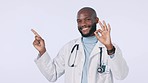 Perfect, pointing and doctor or black man on a studio background for healthcare advertising. Happy, medicine and face portrait of an African nurse or surgeon with an ok gesture or medical information