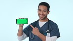 Happy man, doctor and pointing to phone on green screen or mockup in advertising against a studio background. Portrait of Asian, male person or nurse show mobile smartphone, healthcare app or display