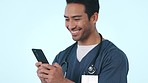 Happy asian man, phone and doctor typing in communication or social media against a studio background. Male person, medical or healthcare nurse smile for online chat or texting on mobile smartphone