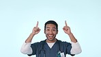 Asian man, doctor and pointing up in advertising or marketing against a studio background. Portrait of male person, medical or healthcare nurse showing notification, alert or message on mockup space