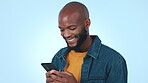 Phone, education or social media with a black man student on a blue background in studio for study research. Learning, mobile or app with a young university or college pupil reading information