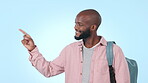 Student, black man and pointing on mockup for list or subject in a studio background with smile. Portrait, education and happy person with backpack show notification or information for advertising 