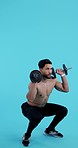 Dumbbell, squats and man exercise, training or workout in studio isolated on a blue background. Weight lifting, body builder and sports fitness of muscle power, energy and strong legs for health.