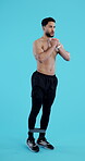 Fitness, resistance and body of a man on a blue background in studio for a full body workout. Exercise, strong or muscle with a young athlete or bodybuilder training shirtless on a vertical backdrop