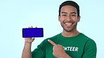 Blue screen, mockup and volunteer with phone pointing to space for marketing, promotion or advertising. Tracking markers, cellphone and portrait of Indian man charity worker by studio background.