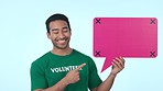 Social media, speech bubble and smile with a volunteer man on a blue background in studio for perfect communication. Portrait, mockup and hand gesture with a happy young asian person showing space