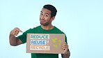 Charity, poster for recycling and a volunteer man on a blue background in studio to promote conservation on earth day. Portrait, smile and green for global warming, climate change or sustainability