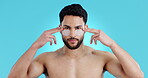 Face, eye mask and skincare of man in studio isolated on a blue background. Portrait, beauty and collagen patches of serious model for dermatology cosmetics, facial treatment and skin health at spa