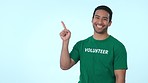 Mockup, pointing and man volunteer in studio for marketing, promotion or advertising. Choice, options and portrait of Indian male community worker with approval or ok hand gesture by white background