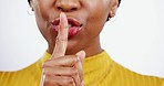 Finger on lips, silence and black woman with secret, whisper or gossip with laughter on white background. Quiet gesture, hand and mouth, confidential with communication and stop noise in studio