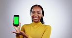 Smartphone, green screen and woman face with hand holding in studio for social media, news or agree on grey background. Phone, mockup and portrait of lady model show platform, sign up or contact info