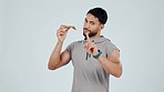 Fast food, face and no by fitness man with pizza in studio, warning or finger protest on grey background. Diet, wrong and portrait of guy personal trainer with hand rejection, stop or emoji mistake
