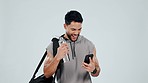 Fitness, winner and man with phone in studio after exercise, training and workout for wellness. Sports, happy and person on smartphone celebrate winning, health target and goals on gray background