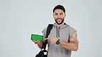 Happy man, personal trainer and phone with green screen, sign up or mockup against a studio background. Portrait male person pointing to mobile smartphone display in fitness, motivation or membership