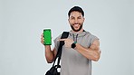 Happy man, personal trainer and pointing to phone green screen, mockup or sign up against a studio background. Portrait male person with mobile smartphone display in fitness, motivation or membership