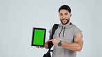 Happy man, personal trainer and tablet with green screen, sign up or mockup against a studio background. Portrait male person pointing to technology display in fitness, motivation or join membership