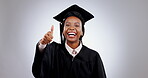 Happy black woman, graduation and thumbs up in success, winning or education against a studio background. Portrait of African female person or student graduate smile with like emoji, yes sign or OK